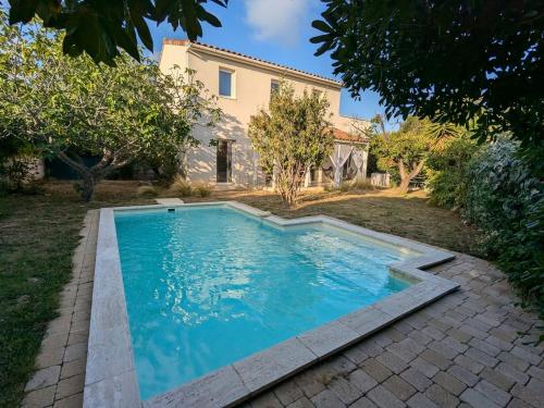 une piscine devant une maison dans l'établissement Villa avec piscine proche Plages, à Pérols