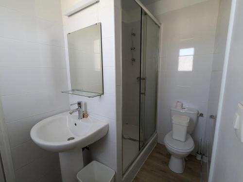 une salle de bain blanche avec un lavabo et des toilettes dans l'établissement Villa avec piscine proche Plages, à Pérols