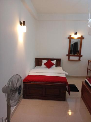 a bedroom with a bed and a fan at Evergreen Cottage in Ella