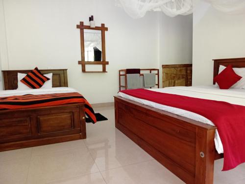 a bedroom with two beds and a cross on the wall at Evergreen Cottage in Ella