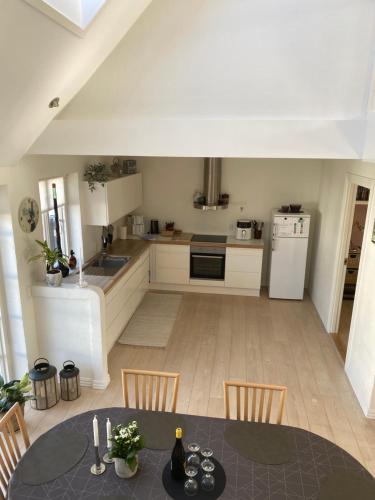 a kitchen with a table and chairs in a room at Dejlig feriehus i den gamle bydel in Løgstør