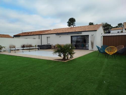 une maison avec une cour avec de l'herbe verte dans l'établissement Charmante Maison 