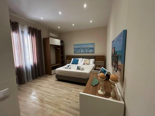 a bedroom with a bed and a table in it at Talos Apartments in San Vito lo Capo