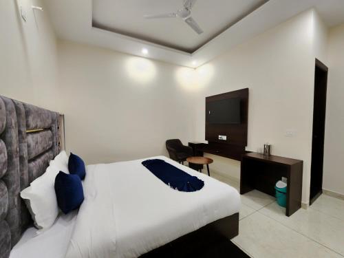 a bedroom with a bed and a desk and a television at Raina's BnB in Solan
