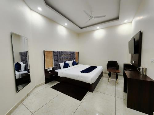 a bedroom with a bed and a desk and a television at Raina's BnB in Solan