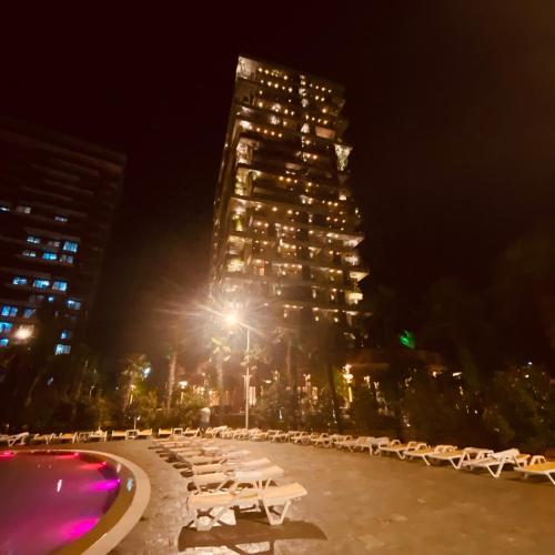 a row of white tables and a building at night at Dreamland Oasis Hotel Chakvi 14310 in Chakvi