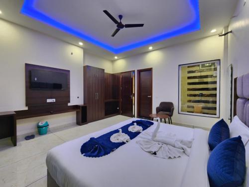 a bedroom with a white bed with a ceiling fan at Raina's BnB in Solan