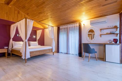 a bedroom with a bed and a desk and a chair at Etenna Beach Bungalows in Cıralı