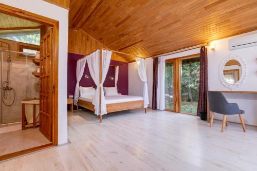 a bedroom with a bed and a glass door at Etenna Beach Bungalows in Cıralı