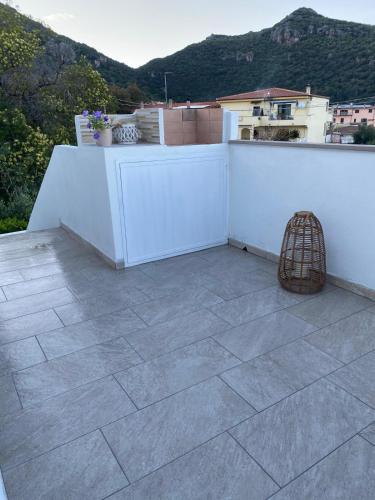 a balcony with a white wall and a bird cage at Casa Matteo in Siniscola