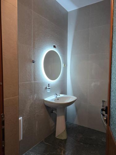 a bathroom with a sink and a mirror at Cortina House Berat in Kuçovë