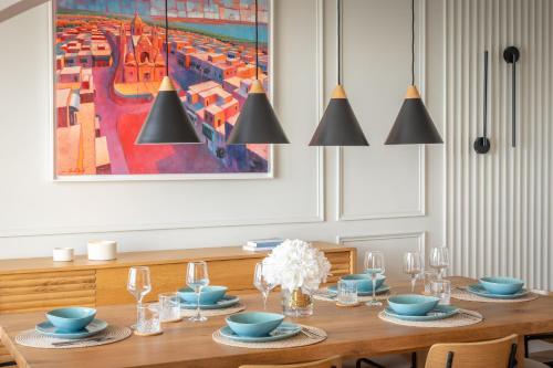 a dining room with a wooden table with chairs and a painting at 2br luxury design with sea views from every room in Sliema in Sliema