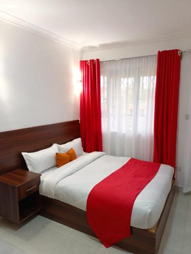 a bedroom with a large bed with red curtains at Rumkin Homes in Lotus Island