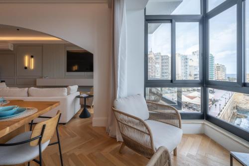 a living room with a bed and a table and chairs at 2br luxury design with sea views from every room in Sliema in Sliema