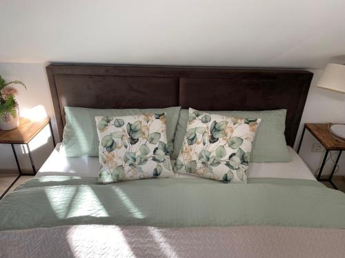 a bed with green sheets and pillows on it at Appartement 105 in Egestorf