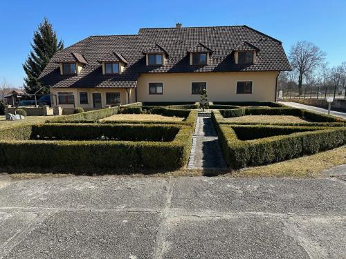 a house with hedges in front of it at Pension Mijami in Dolní Bukovsko