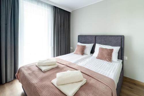 a bedroom with a large bed with two towels on it at Apartamenty Lipowa in Puck