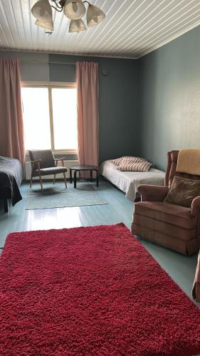 a living room with a couch and a red rug at Taideniityn Maa 1 - 4lle in Varkaus