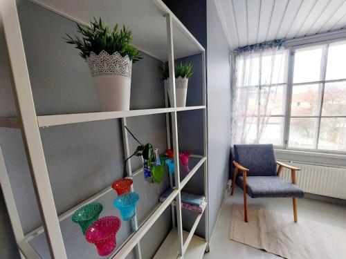 a room with a shelf with potted plants and a chair at Taideniityn Maa 1 - 4lle in Varkaus