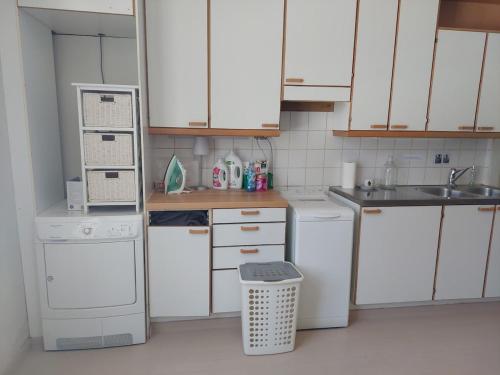 a small kitchen with white appliances and white cabinets at Taideniityn Maa 1 - 4lle in Varkaus