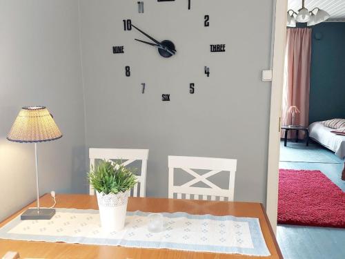 a clock on a wall in a room with a table at Taideniityn Maa 1 - 4lle in Varkaus