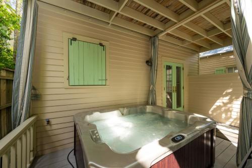 a jacuzzi tub on a porch with a green window at Heron Hideaway in Key West