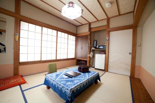 a living room with a table and a window at Hinodeya in Ito