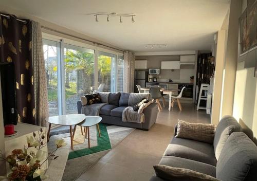 un salon avec un canapé et une table dans l'établissement Les cottages du golf, au Tronchet