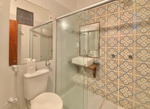 a bathroom with a toilet and a glass shower at Pousada da Renata in Jericoacoara