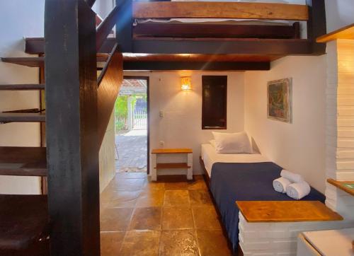 a small bedroom with a bed and a staircase at Pousada da Renata in Jericoacoara