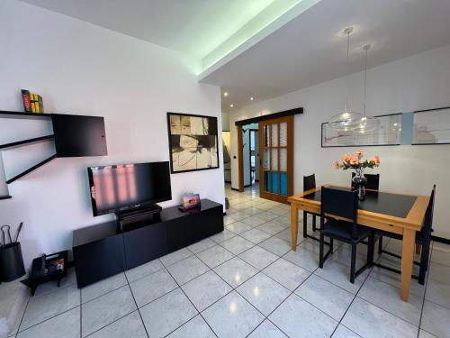 a living room with a television and a dining table at Rimini Casa Vacanze 2 in Rimini