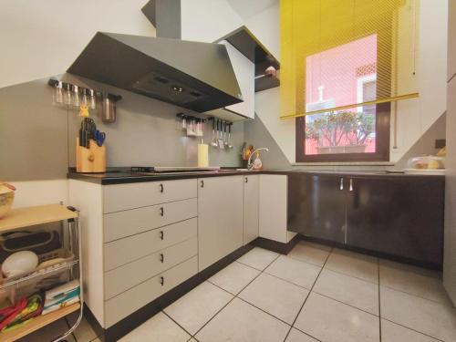 a kitchen with white cabinets and a black counter top at Rimini Casa Vacanze 2 in Rimini