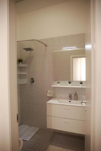a white bathroom with a sink and a mirror at Rimini Casa Vacanze 2 in Rimini
