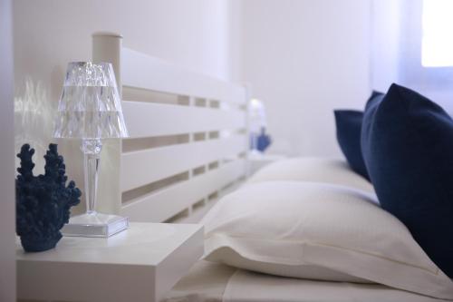 a bed with pillows and a lamp on a table at Rimini Casa Vacanze 2 in Rimini