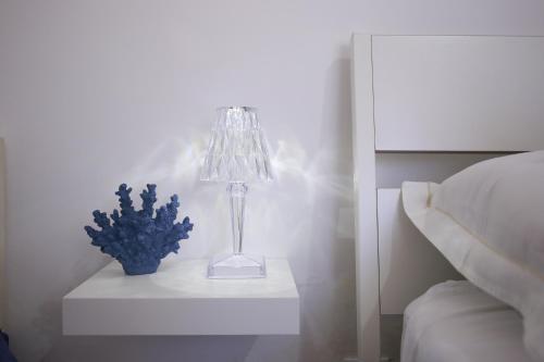 a lamp on a night stand next to a bed at Rimini Casa Vacanze 2 in Rimini