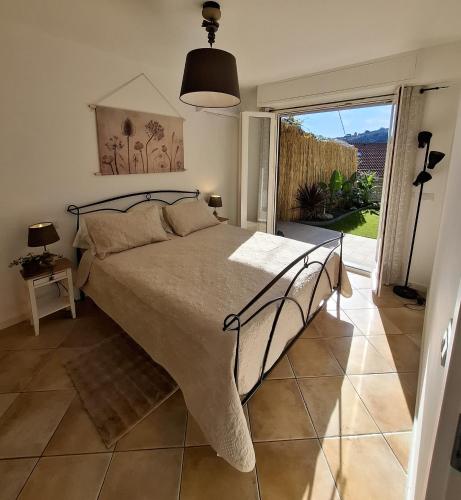 a bedroom with a bed and a sliding glass door at Le Mimose Garden in Bordighera