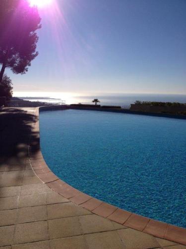 une grande piscine bleue avec l'océan en arrière-plan dans l'établissement Grand studio sur les hauteurs de Cannes, à Mougins