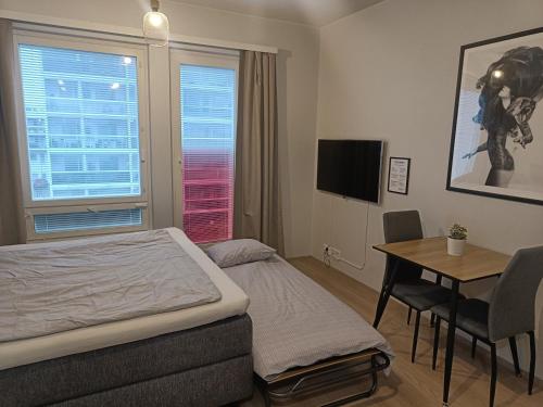 a bedroom with a bed and a desk and a table at Lapin Loiste 1, Modern studio, Free Parking and Wifi in Rovaniemi