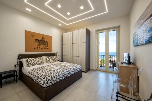 a bedroom with a bed and a television in it at Zen Orlando House Appartamento con vista mare in Taormina
