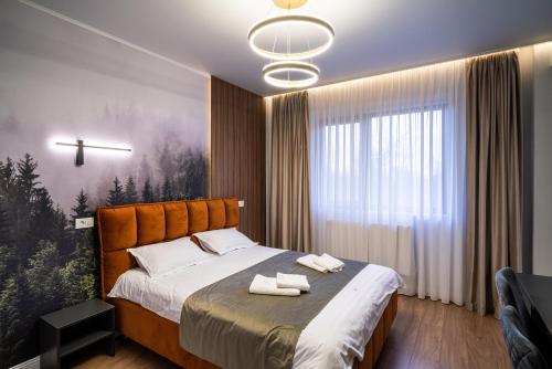 Un dormitorio con una cama con dos toallas encima. en Transalpina Retreat, en Novaci-Străini