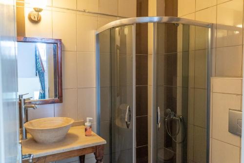 a bathroom with a sink and a glass shower at Esen Apartments in Ula