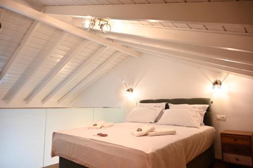 a bedroom with a large white bed with towels on it at Plakares Studio 1 in Kithnos