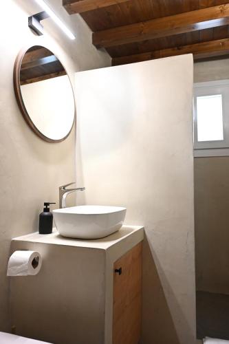 a bathroom with a sink and a mirror at Plakares Studio 1 in Kithnos
