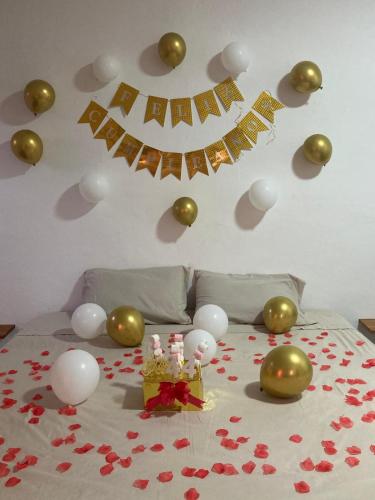 a bedroom with a bed with balloons and a table with hearts at Casa Isla Paraíso in Mazunte