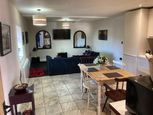 a kitchen and living room with a table and a couch at Old Farm Shop in Herstmonceux
