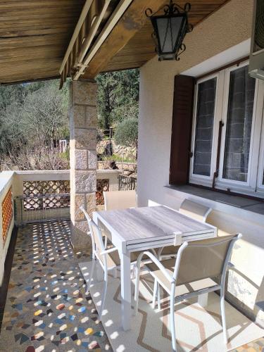 une table et des chaises en bois sur une terrasse dans l'établissement L'Ardéchois, à Vals-les-Bains
