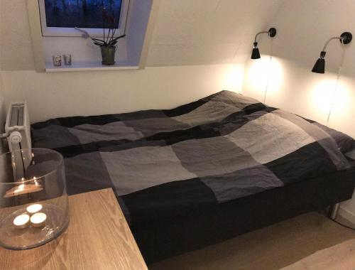 a bed in a room with a wooden table with a bed sidx sidx at 10 min walk from city center in Ribe