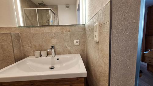 a bathroom with a white sink and a mirror at Ferienwohnungen Salvenmoser Johanna in Scheffau am Wilden Kaiser