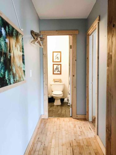 a bathroom with a toilet and a door to a room at Coastal Suite - Harbourview in Ucluelet in Ucluelet