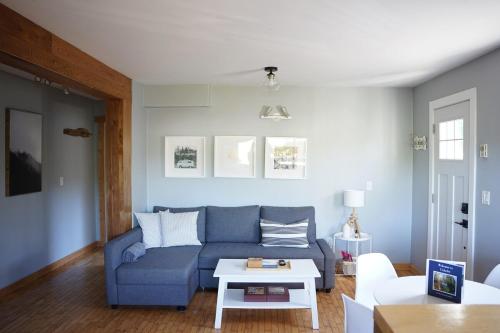 a living room with a blue couch and a table at Coastal Suite - Harbourview in Ucluelet in Ucluelet